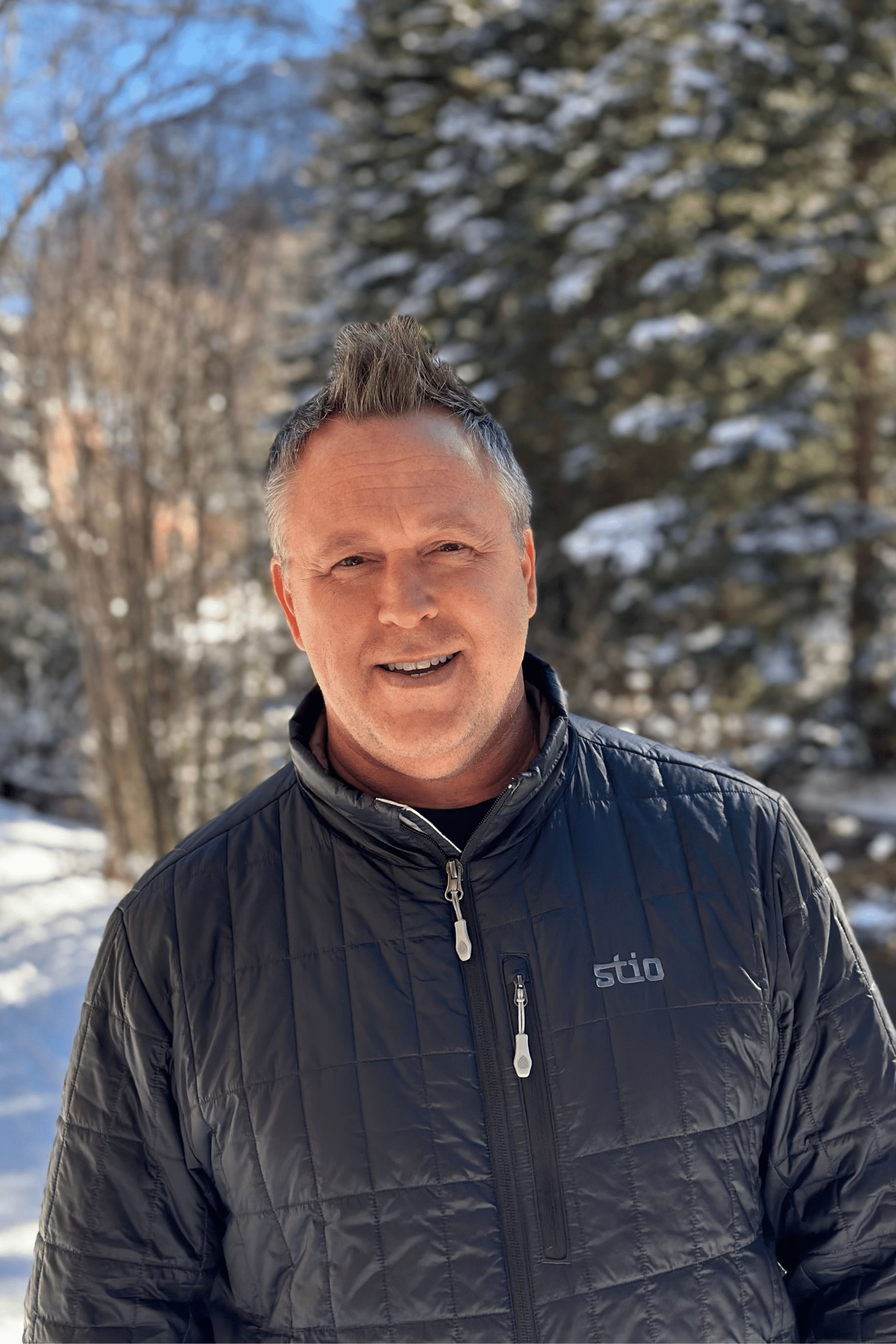 Tony Marusic smiling in front of snowy trees